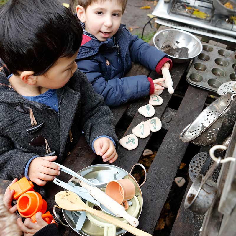 Children playing with mud kitchen top view